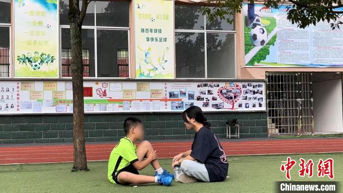 暑假期間，小嘉的姐姐帶他來踢球。原先小嘉不愛說話，踢球之后，更愿意跟家人溝通了?！￡愑裣?攝