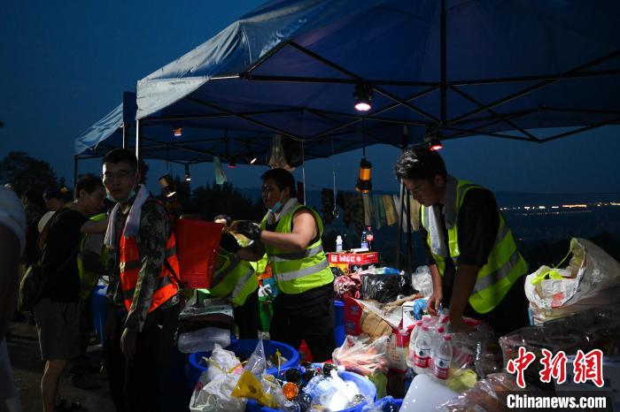 圖為志愿者們分發(fā)物資。　何蓬磊 攝