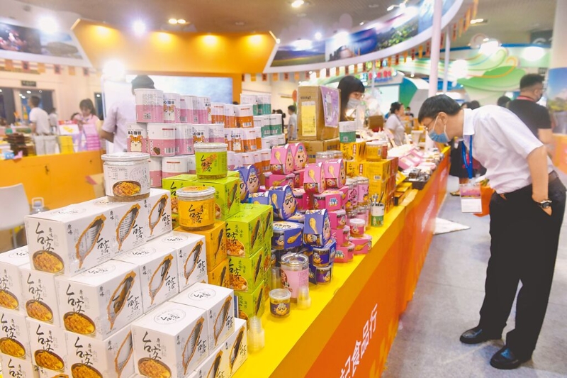 海關(guān)總署1日突然公告，臺灣未完成生產(chǎn)企業(yè)注冊更新的食品業(yè)者“暫停進口”。圖為廈門2021海峽旅游博覽會，臺灣食品展區(qū)吸引參觀者。（中新社）.jpg
