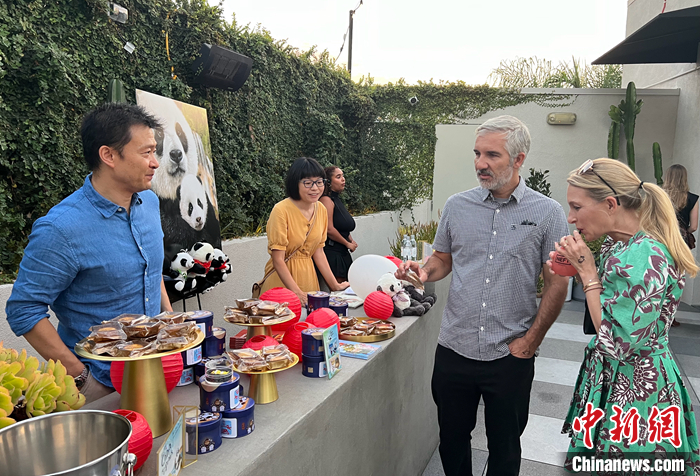 圖為中國駐洛杉磯旅游辦事處主任吳大偉（左一）向美國來賓介紹傳統(tǒng)的中秋佳節(jié)，邀請他們品嘗月餅。 <a target='_blank' href='/'>中新社</a>記者 張朔 攝