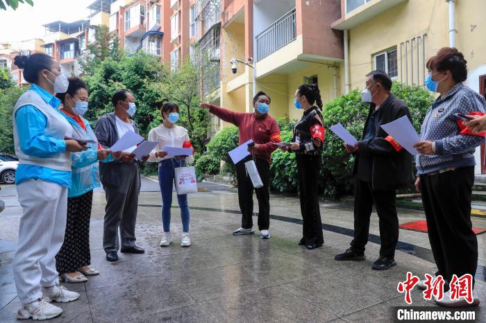 俄木學(xué)正在安排志愿者團(tuán)隊(duì)進(jìn)行入戶排查工作，左五為俄木學(xué)。　王磊 攝