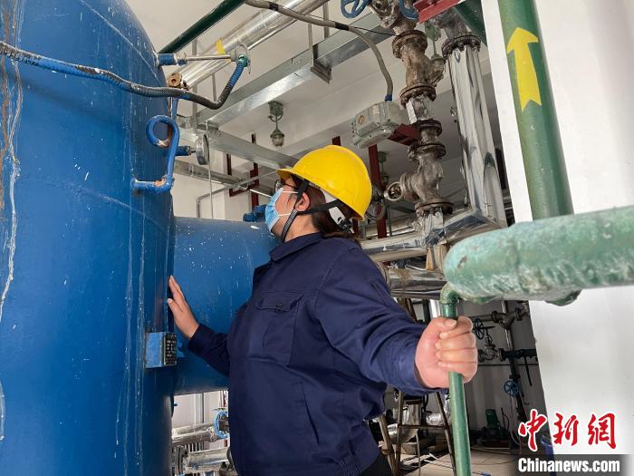 圖為王衛(wèi)玲認真檢查鍋爐設備。　朱永龍 攝