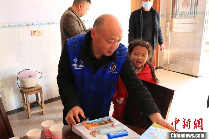 常山縣志愿者給救助對(duì)象送文具?！钪胰?攝