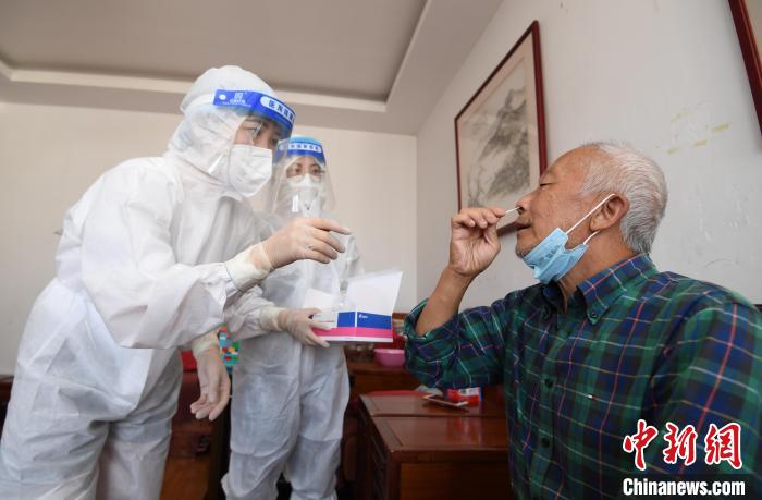 圖為貴陽市南明區(qū)望城街道的工作人員上門指導(dǎo)老年人進行抗原檢測。　趙松 攝