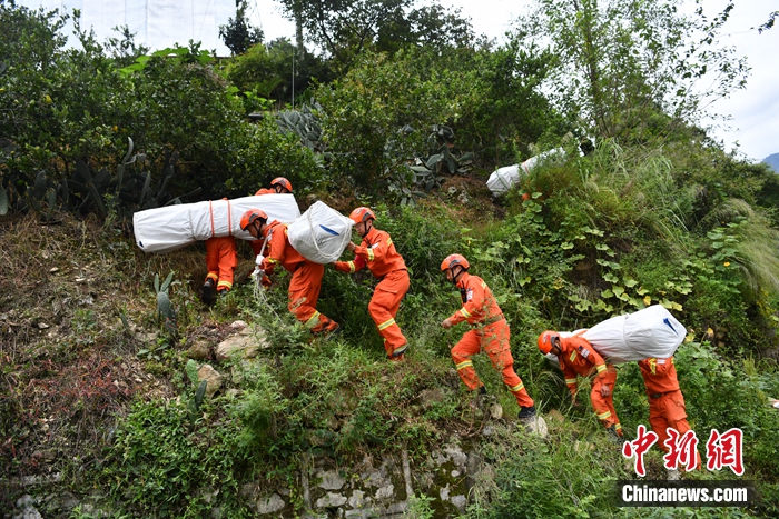 消防隊員背著帳篷上山。張浪 攝