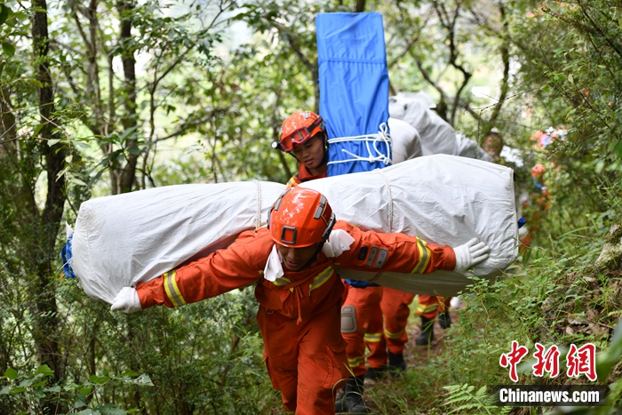 消防隊員背著帳篷上山。張浪 攝