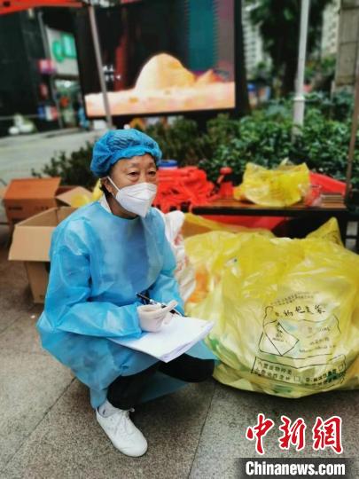 陳福珍在南明區(qū)花果園花中社區(qū)參與志愿工作登記醫(yī)療物資?！∥榇喝A供圖