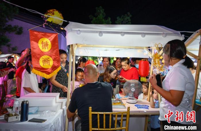 現(xiàn)場,民眾“打卡”糖畫攤位 江成城 攝