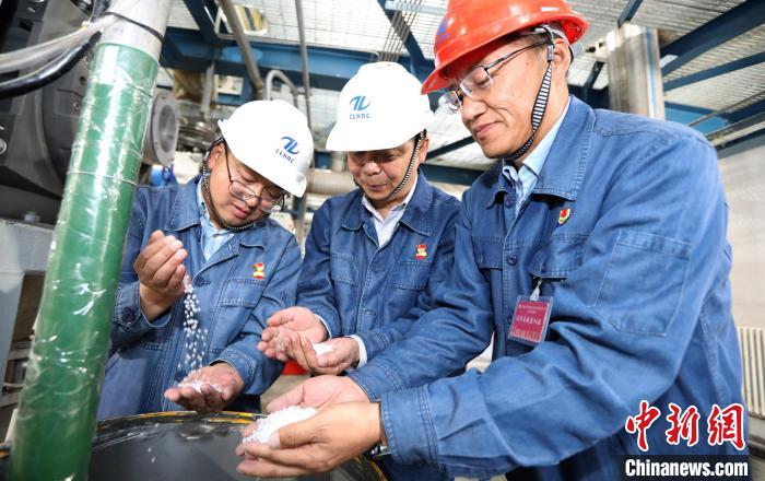 工作人員在粒料取樣口查看產(chǎn)品情況。　李秦 攝