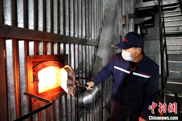 供熱工人查看供熱鍋爐燃燒情況?！∩厶炖?攝