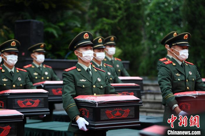 武警官兵緩步將烈士遺骸棺槨轉(zhuǎn)運(yùn)至靈車上。　郭傳伍 攝