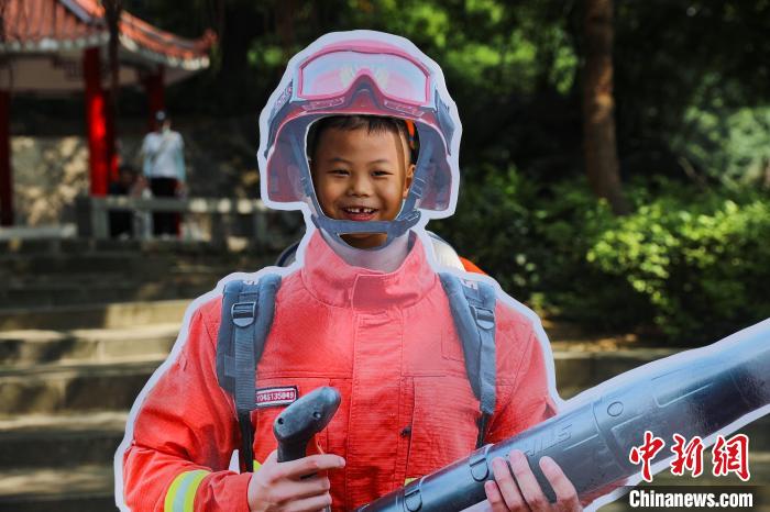 游客參與變身消防員活動(dòng)?！±钤x 攝