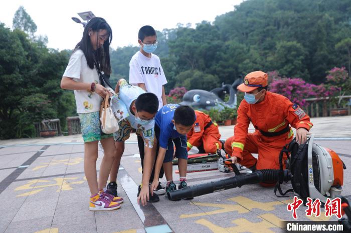 游客正在體驗(yàn)滅火裝備?！±钤x 攝