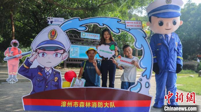 游客在防火打卡欄上合影?！±钤x 攝