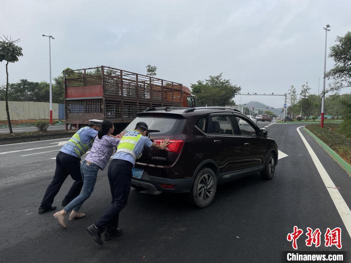 佛山高明公安警輔人員協(xié)助司機(jī)將故障車輛推至安全區(qū)域?！∥轲┤?攝
