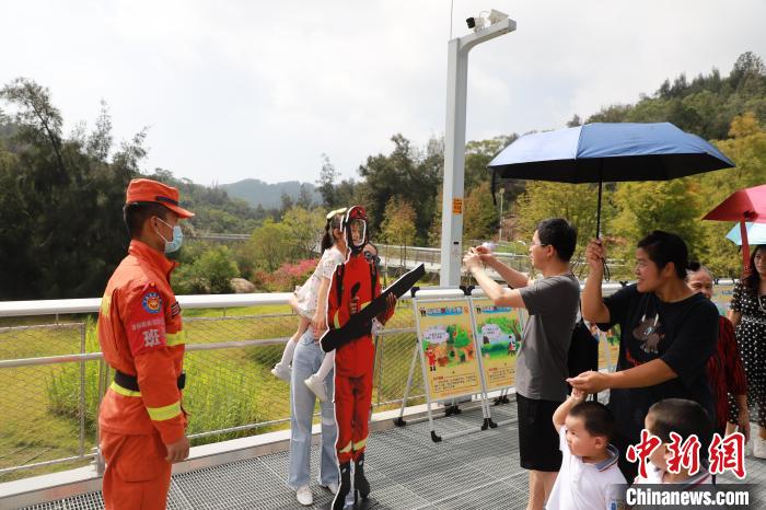 游客在森林消防戰(zhàn)斗員人物展板區(qū)拍照合影?！「唢w 攝