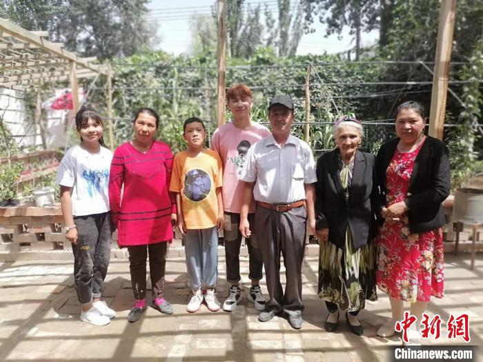 108歲老人努爾·依地?zé)崴?右二)喜愛勞作，澆花，喂羊，烤包子等都親力親為。圖為老人與部分子孫。　朱景朝 攝