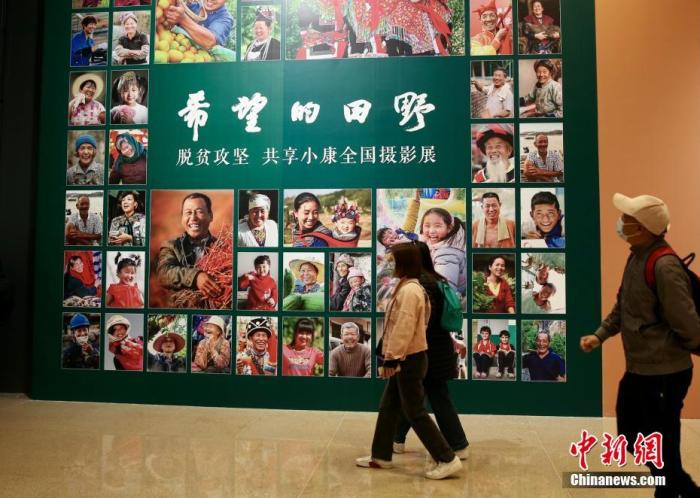 4月9日，由中國文學(xué)藝術(shù)界聯(lián)合會(huì)、中國國家博物館和中國攝影家協(xié)會(huì)聯(lián)合主辦的“希望的田野——脫貧攻堅(jiān) 共享小康全國攝影展”在國家博物館南廳正式開幕。本次展覽通過不同時(shí)期近150名攝影家的近180幅作品，生動(dòng)記錄脫貧攻堅(jiān)這一偉大歷史實(shí)踐，以影像的力量展示和反映全面建成小康社會(huì)取得的偉大成就。展覽共分為攻堅(jiān)與圓夢(mèng)兩個(gè)部分，包含產(chǎn)業(yè)扶貧、就業(yè)扶貧、異地搬遷扶貧、教育扶貧、文化扶貧等內(nèi)容。圖為觀眾進(jìn)入展廳參觀展覽。<a target='_blank' href='/'>中新社</a>記者 易海菲 攝