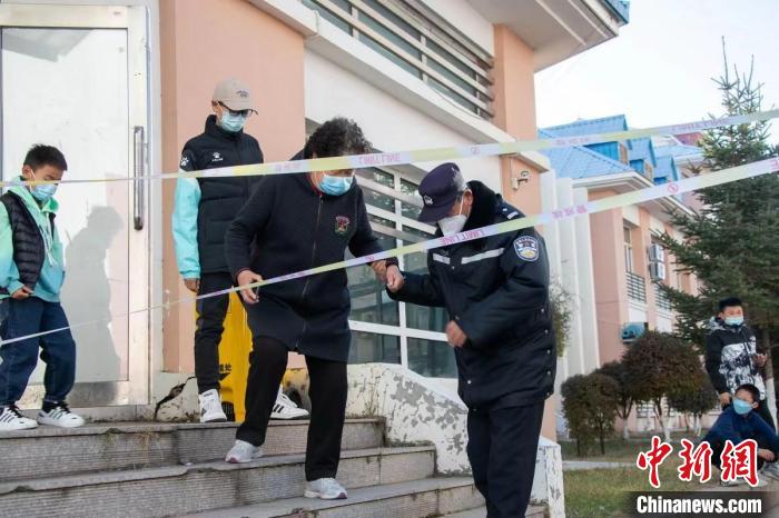 圖為王福幫助居民下樓梯?！∈?攝