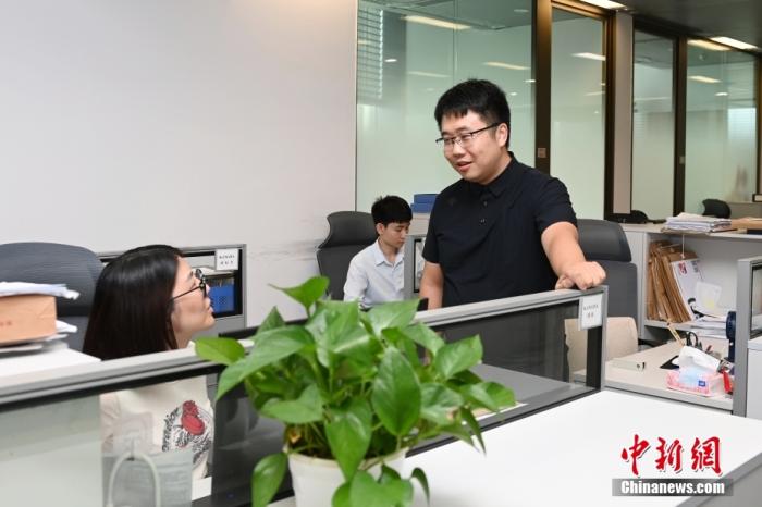 圖為9月23日，廣東廣州，余偉權(quán)(右一)和同事討論案件。 <a target='_blank' href='/'>中新社</a>記者 陳楚紅 攝