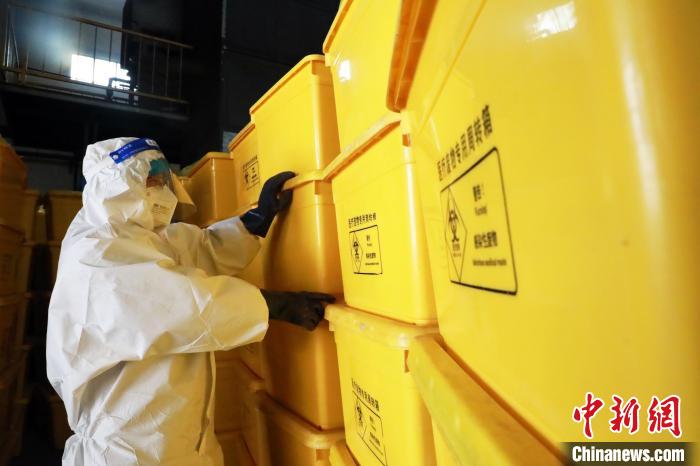 圖為工作人員搬運醫(yī)療廢物專用周轉(zhuǎn)箱?！∥航ㄜ?攝