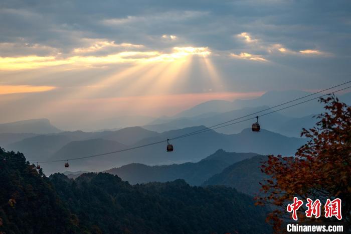 清晨的陽(yáng)光透過云層照在山間?！⒅铱?攝