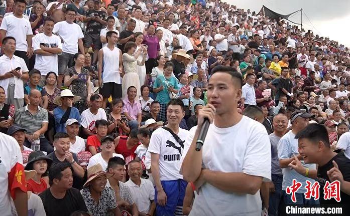 圖為臺(tái)盤村村民王再貴擔(dān)任球賽解說(shuō)?！≡?攝