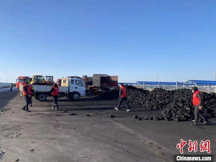 圖為工作人員正在協(xié)助牧民裝煤?！氁舳继m 攝