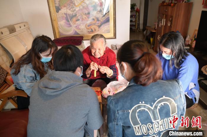 圖為周有玉在家中教授居民串珠手工藝品制作技藝。　陳鑫 攝