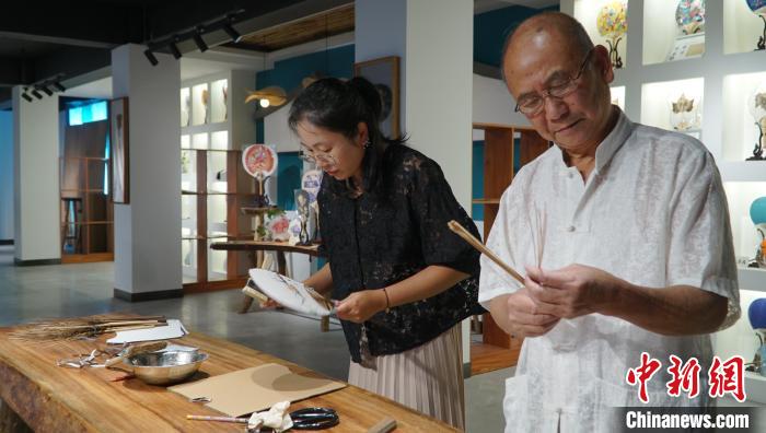 黃碩夫(右)和女兒黃可人(左)一起制作團(tuán)扇。　李嬌陽(yáng) 攝