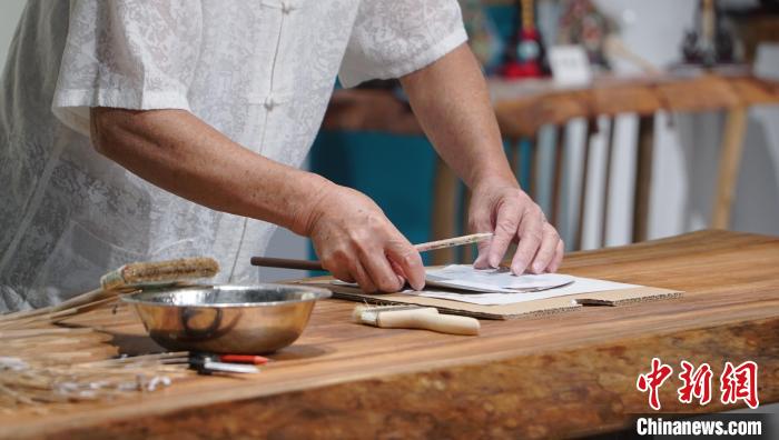 黃碩夫正在粘貼扇面?！±顙申?yáng) 攝