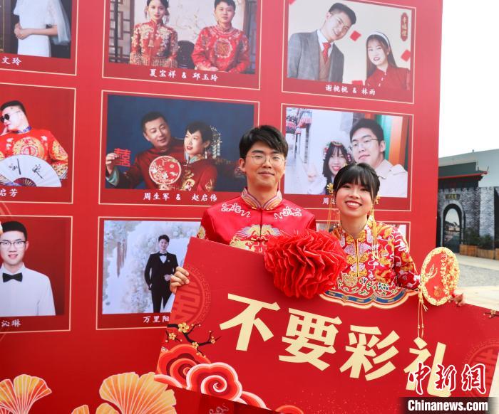 圖為參加“不要彩禮要幸?！奔w婚禮的新人在合影留念?！⒂駶?攝