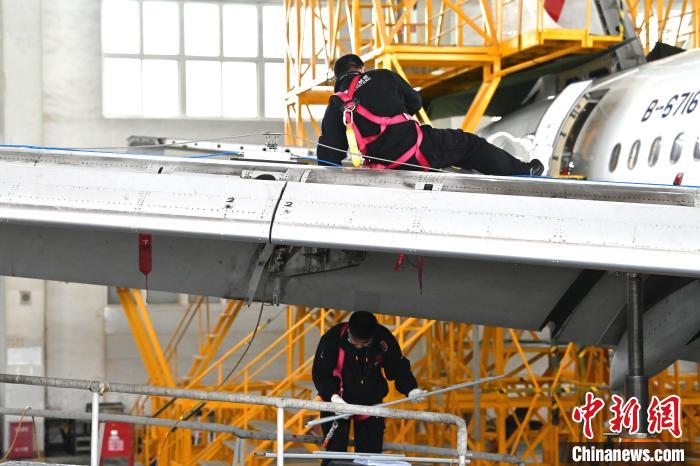 圖為工作人員進行飛機大翼后緣檢修工作?！±顏嘄?攝