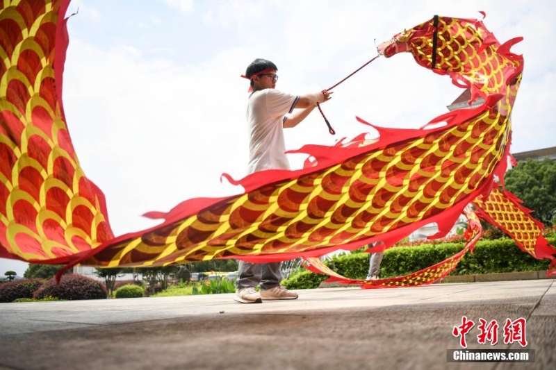 資料圖：低年級的學(xué)生為考生舞龍加油。 楊華峰 攝