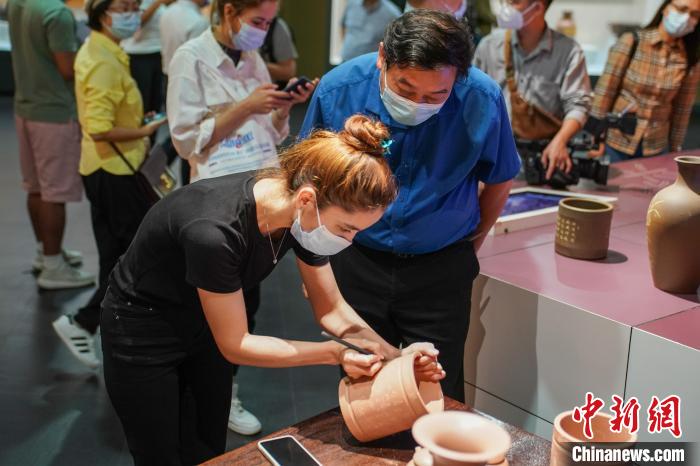 境外媒體代表在坭興陶制品上刻字?！￡惞谘?攝