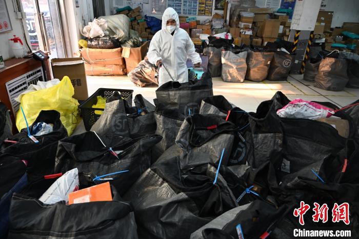 圖為工作人員正在對(duì)快遞包裹進(jìn)行消殺?！⑽娜A 攝