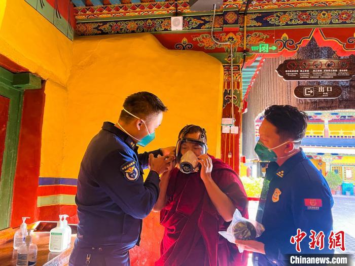 圖為消防員指導(dǎo)僧人學(xué)習(xí)佩戴防煙防毒面具?！±_市消防救援支隊(duì)供圖