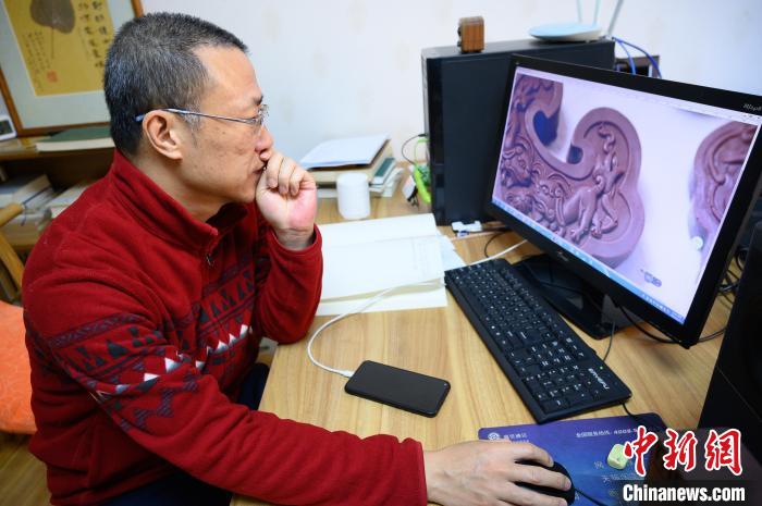 孫晟坐在電腦前，瀏覽設(shè)計(jì)成品圖片。　韋亮 攝