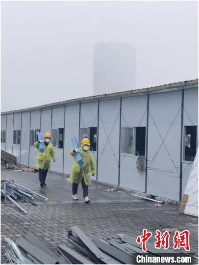 圖為工人正在搬運(yùn)材料?！≈薪ㄈ止﹫D