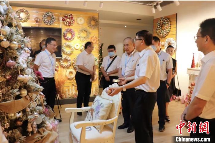 吳發(fā)彬向參觀者介紹圣誕節(jié)產(chǎn)品?！∈茉L者供圖