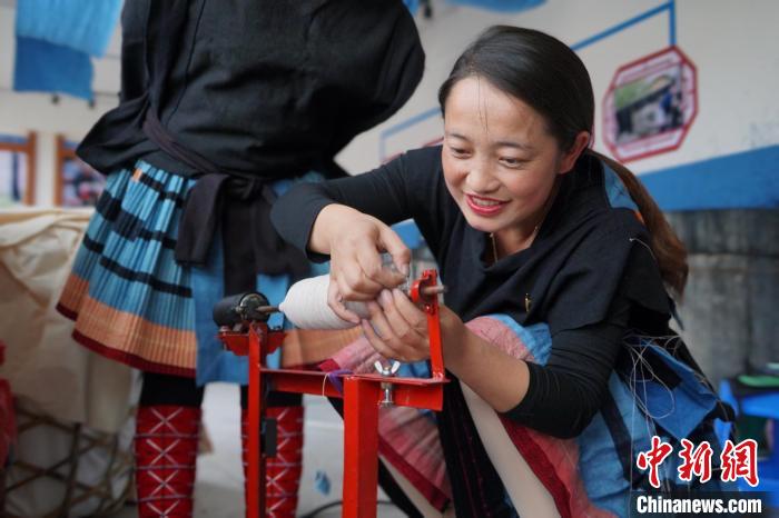 圖為黎秋億正在紡織。　韋國(guó)政 攝