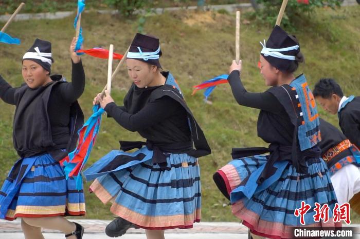 圖為白褲瑤婦女在跳“猴棍舞”，多彩的百褶裙隨風(fēng)飄舞。　韋國(guó)政 攝