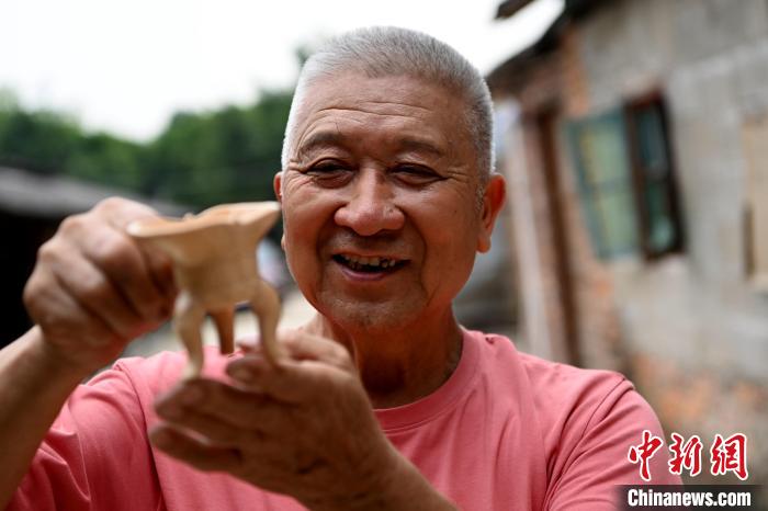 林俊展示剛燒制好的漳窯瓷器作品，喜形于色?！埥鸫?攝