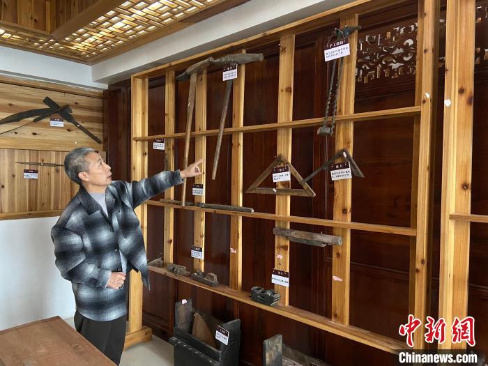 圖為葉偉平向前來參觀的民眾介紹修復(fù)古建筑時使用的工具。　劉玉潔 攝