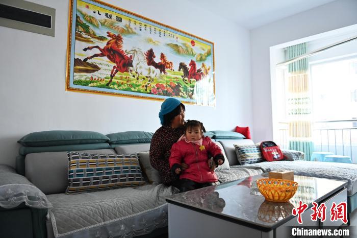 12月5日，宕昌縣哈達鋪鎮(zhèn)生態(tài)及地質(zhì)災(zāi)害避險搬遷集中安置點內(nèi)，已搬遷居民與孫女閑坐?！±顏嘄?攝