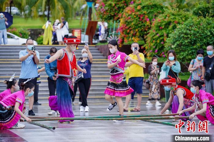 資料圖：三亞大小洞天旅游區(qū)入口，工作人員跳竹竿舞迎接游客?！●樤骑w 攝