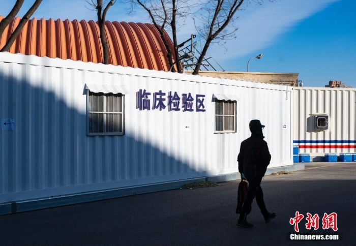 12月15日，北京市“健康豐臺(tái)”微信公眾號(hào)發(fā)布消息，為方便群眾就醫(yī)，豐臺(tái)區(qū)豐體方艙發(fā)熱門診今日開診。豐體方艙發(fā)熱門診位于豐臺(tái)區(qū)西四環(huán)南路55號(hào)豐臺(tái)體育中心院內(nèi)，全天24小時(shí)開診。主要服務(wù)16至65周歲，無基礎(chǔ)疾病，非急診、無有創(chuàng)治療的普通上呼吸道感染發(fā)熱患者。圖為一位市民經(jīng)過方艙發(fā)熱門診臨床檢驗(yàn)區(qū)設(shè)施。 <a target='_blank' href='/'>中新社</a>記者 侯宇 攝
