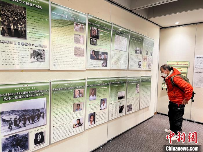 日本侵華戰(zhàn)爭圖片展12日至18日在日本東京舉行。圖為日本民眾參觀圖片展?！≈斐筷?攝