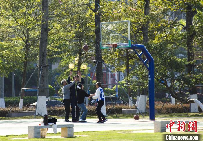 圖為市民、游客在防城港市公園廣場打籃球?！〉岳顝?qiáng) 攝