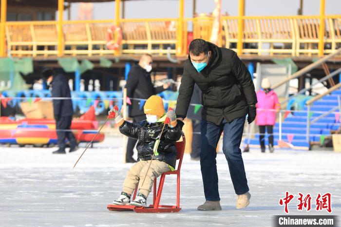 游客們體驗(yàn)冰上爬犁?！『嚏?攝